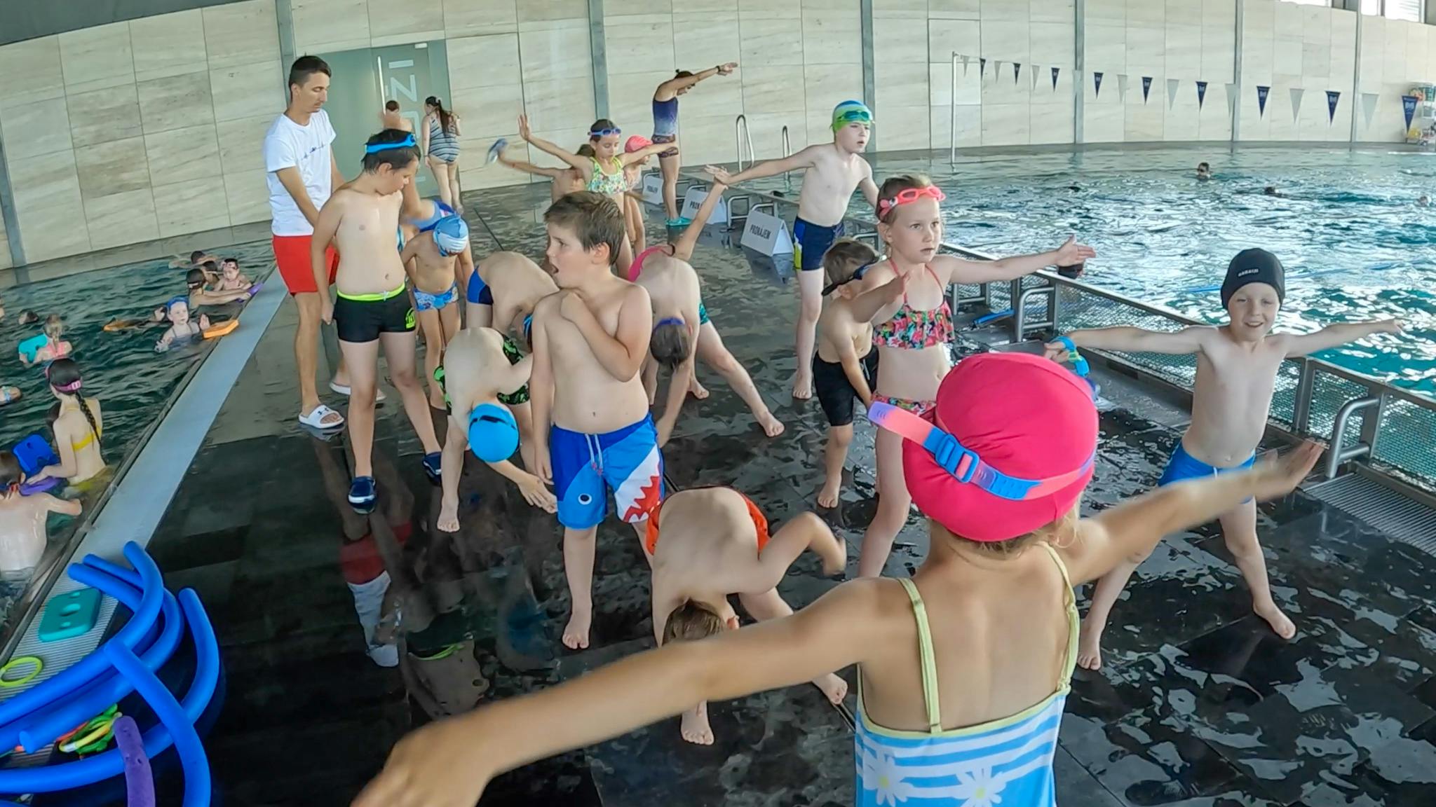 Děti na bazéně při rozcvičce.